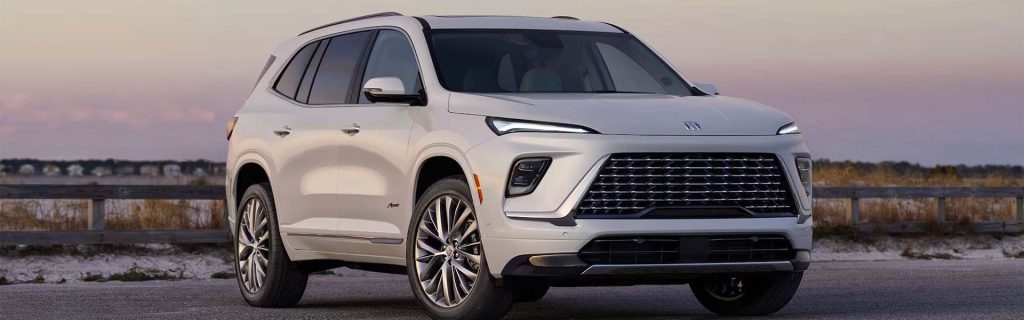 A white SUV parked near a beach at sunset.