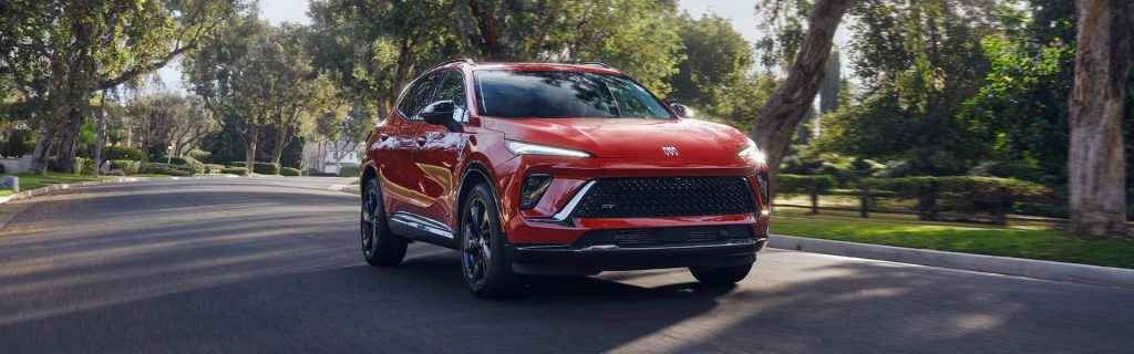 2026 Buick Envision driving on a tree-lined suburban road