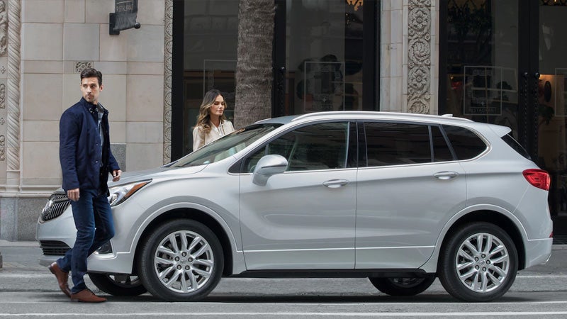 A men and Women Standing Both Side of White Car