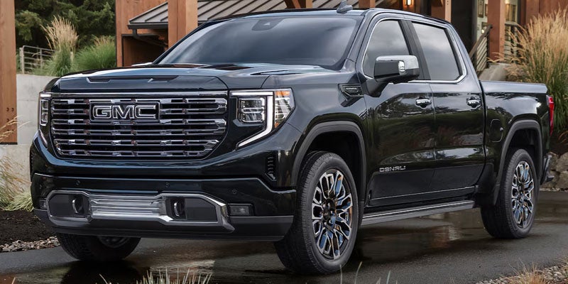 Black 2026 Sierra 1500 outside of wooden house
